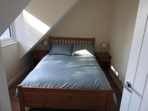 a bedroom with a bed with blue sheets and a window at The Shed @ Stares Farm Cottage in Shedfield