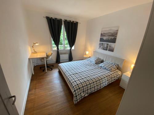 Schlafzimmer mit einem Bett, einem Schreibtisch und einem Fenster in der Unterkunft Fabuleux T3 de 85 m2, situé au calme avec grand parking gratuit privé ,Fibre wifi in Saint-Gaudens