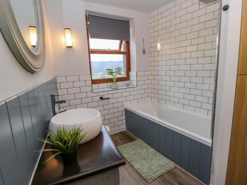 a bathroom with a tub and a toilet and a sink at 19 The Village in Holmfirth