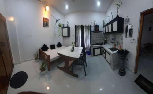 a living room with a table and a kitchen at CLIFF HEAVEN in Varkala