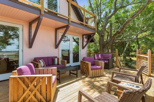 una terraza con muebles morados en una casa en Folly Vacation Vintage Cottage with Stunning Views 218 en Folly Beach