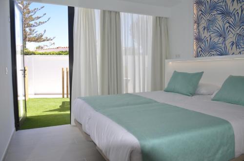 een slaapkamer met een bed en een glazen schuifdeur bij Alsol Bungalows Todoque - Adults Only in Playa del Inglés