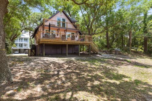 a large house with a deck in the woods at Folly Vacation Vintage Cottage with Stunning Views 218 in Folly Beach