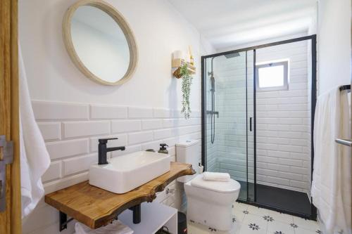 een badkamer met een wastafel, een toilet en een spiegel bij Villa Ria in Ovar