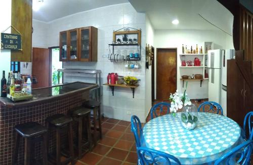 a kitchen with a table and chairs and a counter at Casa Azul in Caraguatatuba