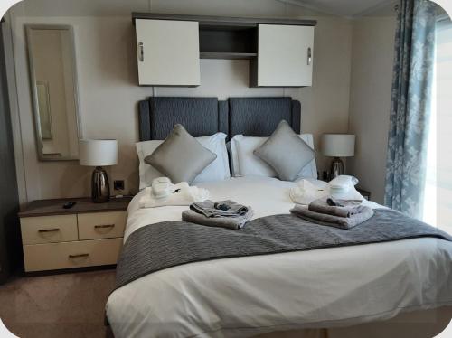 a bedroom with a large white bed with towels on it at Sea View Lodge in Brixham