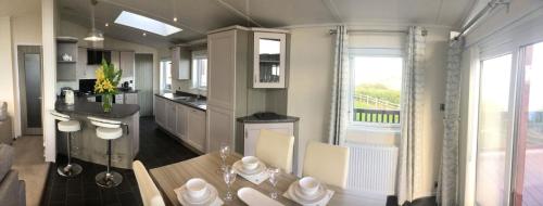 a kitchen with a table and chairs and a window at Sea View Lodge in Brixham