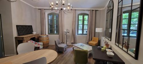un salon avec une table et des chaises et une salle à manger dans l'établissement Une chambre à Uzès, à Uzès