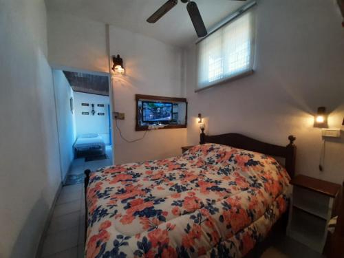 a bedroom with a bed with a floral comforter at Villa Azul in Buenos Aires