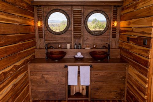 a bathroom with two sinks and two windows at Aurari Camp in Serengeti