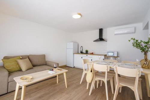 een woonkamer met een bank en een tafel en stoelen bij Villa Ria in Ovar