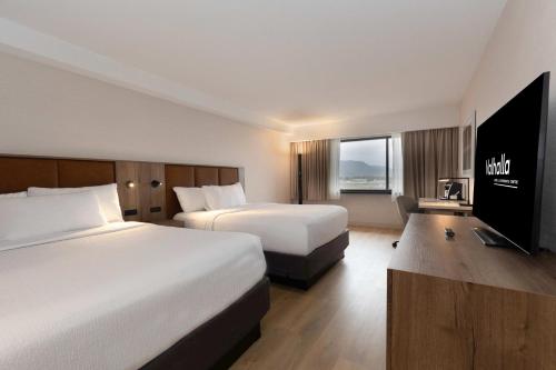 um quarto de hotel com duas camas e uma televisão de ecrã plano em Valhalla Hotel & Conference Centre em Thunder Bay