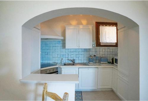 a kitchen with white cabinets and an archway at Residenza Grazia sul mare in Abbiadori