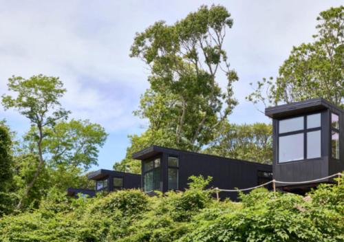 a black house on a hill with trees at AutoCamp Cape Cod in Falmouth