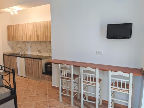 a kitchen with a bar and a tv on the wall at Chrysiis House 2 in Maltezana
