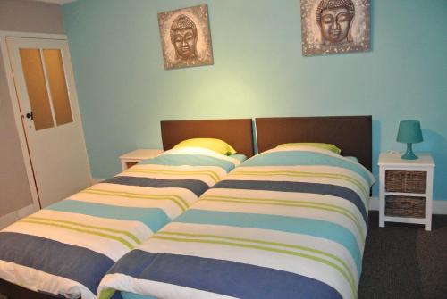 1 dormitorio con 2 camas y 2 cuadros en la pared en La Doyenne, en Francorchamps