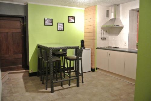 フランコルシャンにあるLa Doyenneの緑の壁のキッチン(テーブル、椅子付)