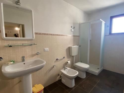 a bathroom with a sink and a toilet and a shower at Agriturismo Il Melograno in Cannizzara