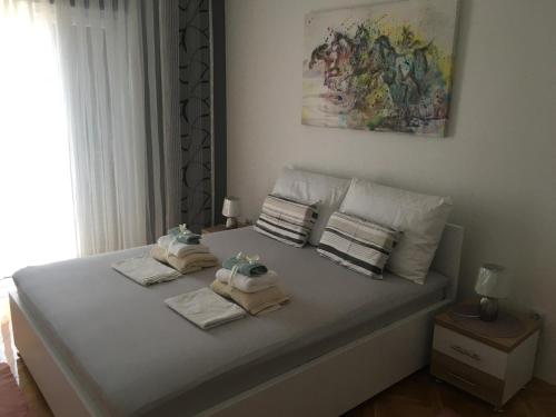 a white bed with towels on top of it at Apartments SARA in Slatine