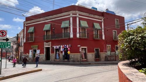 a red building with people walking in front of it at CAPITAL O Meson De La Fragua in Guanajuato