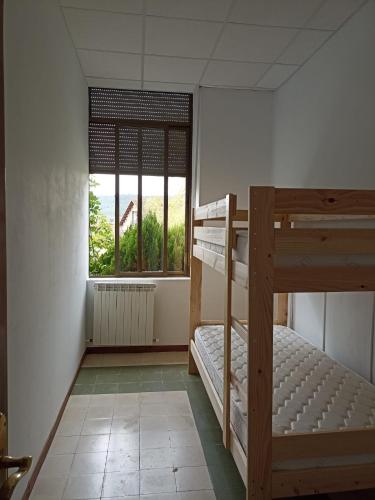 a bedroom with two bunk beds and a window at Albergue de Siresa in Siresa
