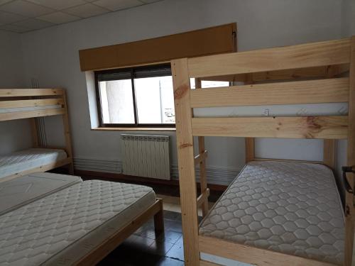 1 dormitorio con 2 literas y ventana en Albergue de Siresa en Siresa