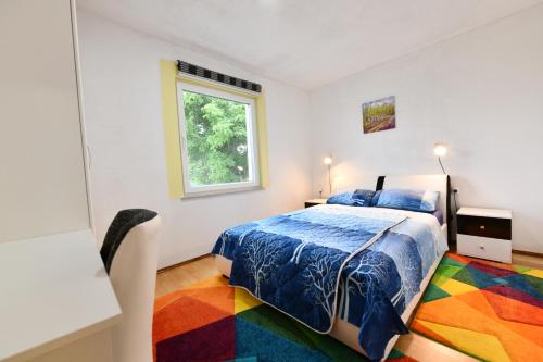 a bedroom with a colorful bed and a window at Lora in Rakovica