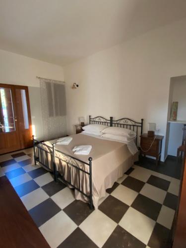 a bedroom with a bed and a checkered floor at Agriturismo Il Melograno in Cannizzara