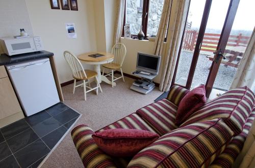 a living room with a couch and a table at Hafoty Farm Cottages in Caernarfon