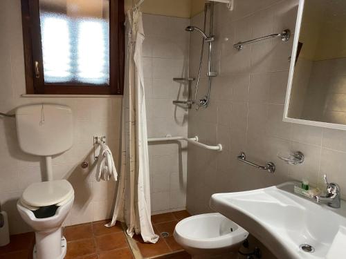 uma casa de banho com um WC branco e um lavatório. em Agriturismo Il Melograno em Cannizzara