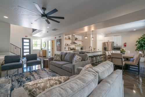 a living room with two couches and a kitchen at The Latitude Adjustment, located close to Golf,Sand Dunes, Reservoir & National Parks in Hurricane