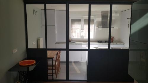 una cocina con armarios blancos y una mesa con taburete en Apartamento Vadillos - VuT 09-401, en Burgos