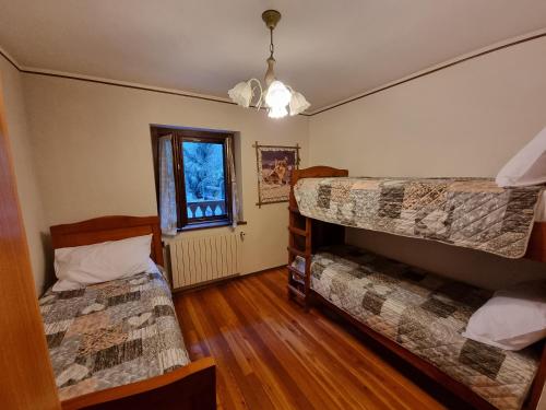 a bedroom with two bunk beds and a window at APPARTAMENTO NONNA LEA in Alagna Valsesia