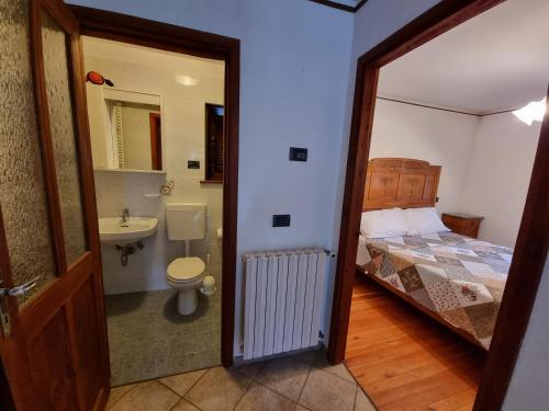 a bathroom with a bedroom with a bed and a sink at APPARTAMENTO NONNA LEA in Alagna Valsesia