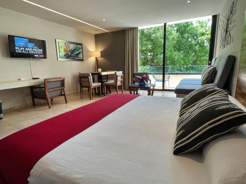 a bedroom with a large bed and a living room at KAAB South Beach - Beautiful Big Studio - Rooftop pool ocean view in Playa del Carmen