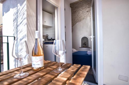 una bottiglia di vino e due bicchieri di vino su un tavolo di B&B Casa Martino SEA VIEW a Vietri
