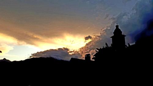 a silhouette of a building with the sunset in the background at Sole & Lago-Lake in Maccagno con Pino e Veddasca
