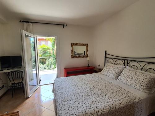 a bedroom with a bed and a sliding glass door at Albergo Campagnola in Lazise