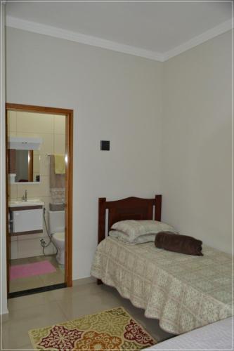 a bedroom with a bed and a bathroom with a mirror at Recanto da Valtana com piscina in Olímpia