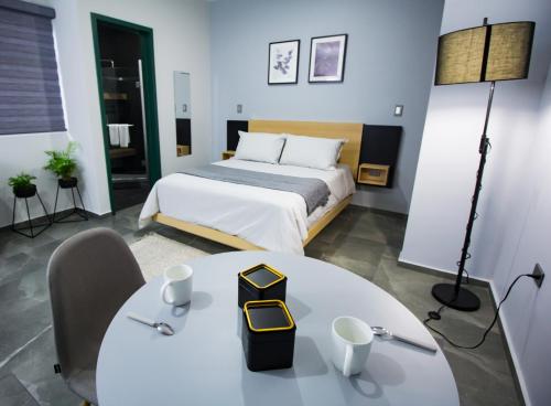 a hotel room with a bed and a table and a table and chairs at Nidah Condominios in Durango