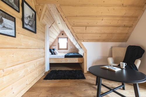 a room with a bed and a table in a cabin at Cyrhlański Wypas in Zakopane