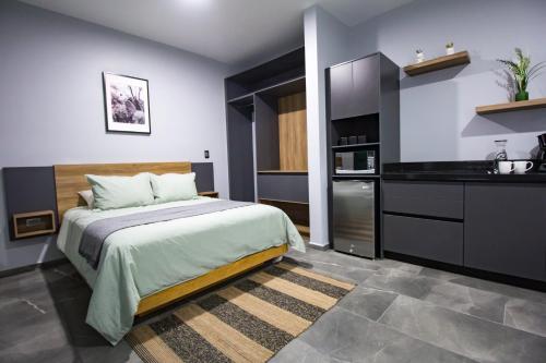 a bedroom with a large bed and a kitchen at Nidah Condominios in Durango