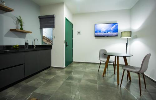 a kitchen with a table and chairs and a sink at Nidah Condominios in Durango