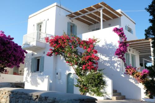 a white building with flowers in front of it at ARK Tinos in Agios Ioannis Tinos