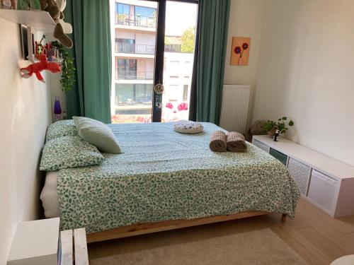 a bedroom with a bed and a window at Cozy two bedroom Apartment near city centre Gent in Ghent
