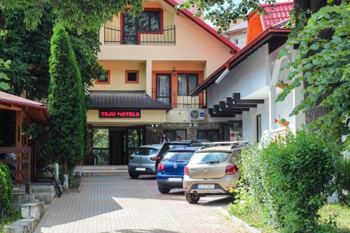 a street with cars parked in front of a building at Teju Hotels in Slănic