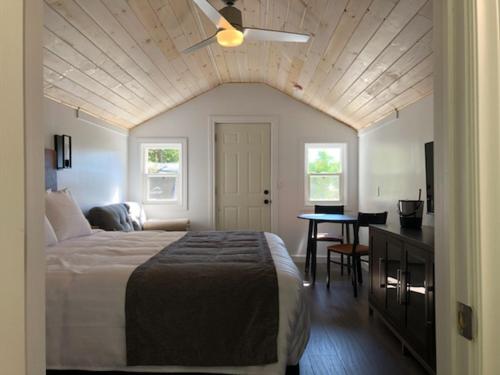 a bedroom with a bed and a table and a ceiling at Adventure the Bruce Inn - Recently Renovated With Outdoor Hot Tub in Tobermory
