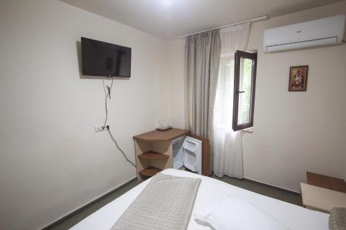 a bedroom with a bed and a tv on the wall at Teju Hotels in Slănic