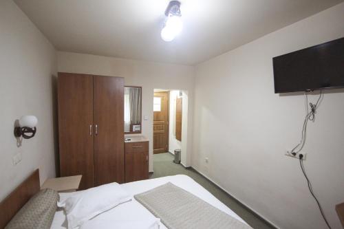 a bedroom with a bed and a flat screen tv at Teju Hotels in Slănic