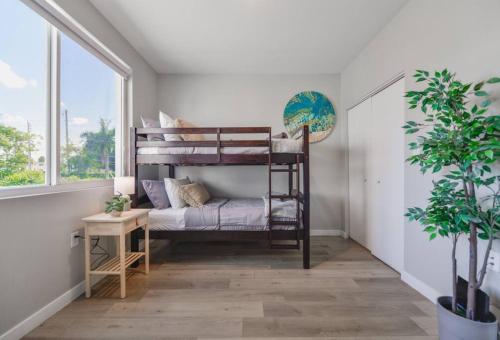 een slaapkamer met 2 stapelbedden in een kamer met een plant bij Fantastic Townhouse 15minutes from the Beach in Miami